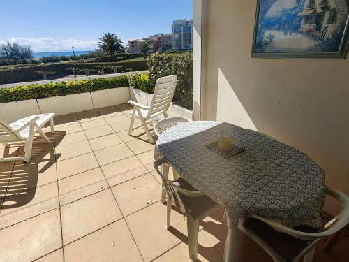 une table et des chaises assises sur une terrasse dans l'établissement T2 charmant au Cap d'Agde - Terrasse et plage à 30m - FR-1-607-6, au Cap d'Agde
