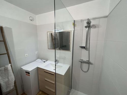 une salle de bain blanche avec une douche et un lavabo dans l'établissement Studio confort avec piscine, à 30m de la mer, Cap d'Agde - FR-1-607-76, au Cap d'Agde