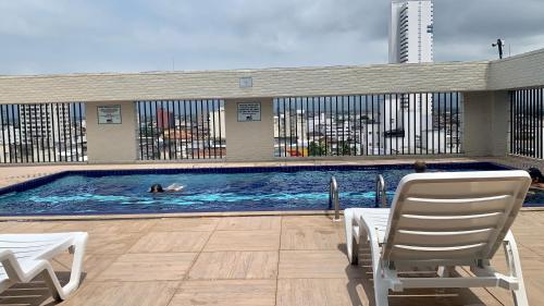 eine Person schwimmt in einem Pool in der Unterkunft Flat 406A com piscina in São Vicente