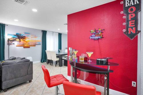 uma parede vermelha numa sala de estar com uma mesa em Escape GameRoom, BAR, BBQ, Spacious,KING Bed, All Luxury mattresses, Near Beach, 6 blocks away from Bars, Nite Clubs, Res, Shops em Miami