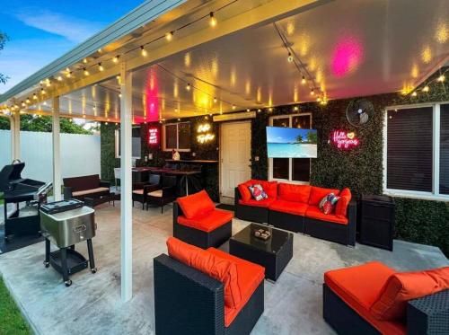 a patio with couches and a television and a table at Escape GameRoom, BAR, BBQ, Spacious,KING Bed, All Luxury mattresses, Near Beach, 6 blocks away from Bars, Nite Clubs, Res, Shops in Miami