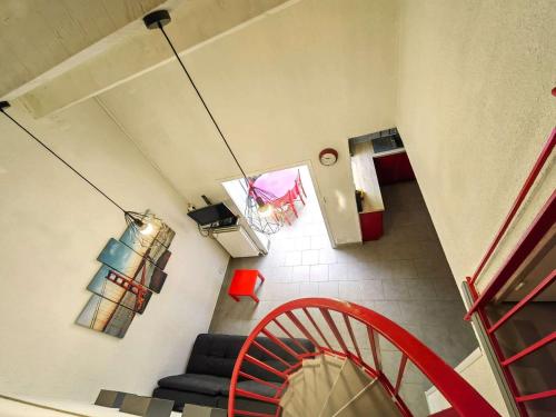 - un salon avec une chaise rouge dans l'établissement Villa Mitoyenne avec Piscine, Parking Privé, à 15 Min de la Plage - FR-1-607-126, au Cap d'Agde