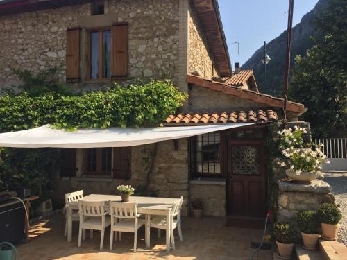 a patio with a table and chairs and an umbrella at Maison avec vue sur le Vercors in Beauregard-Baret