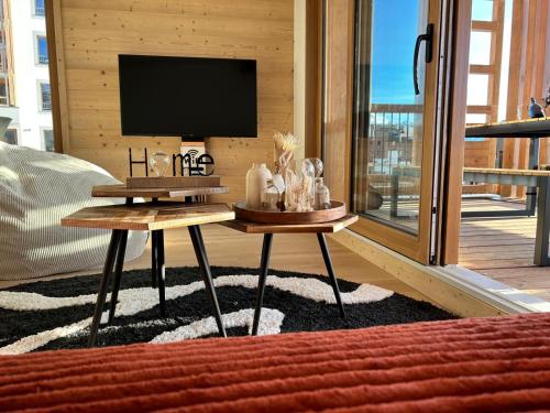 a living room with a tv and a table at Résidence Phoenix C by Leavetown Vacations in L'Alpe-d'Huez