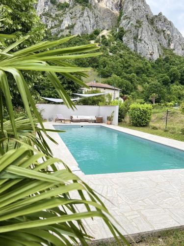 a swimming pool with a mountain in the background at Maison avec vue sur le Vercors in Beauregard-Baret