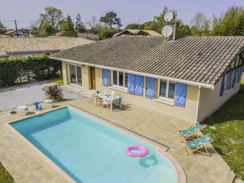 une maison avec une piscine devant une maison dans l'établissement Maison avec piscine 4 chambres, 8 couchages Biscarrosse Bourg proche centre ville., à Biscarrosse