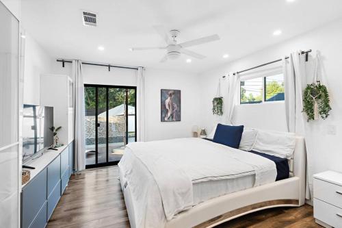 een witte slaapkamer met een groot bed en een raam bij ৎ୭ Luxury Reseda with Pool ৎ୭ in Los Angeles
