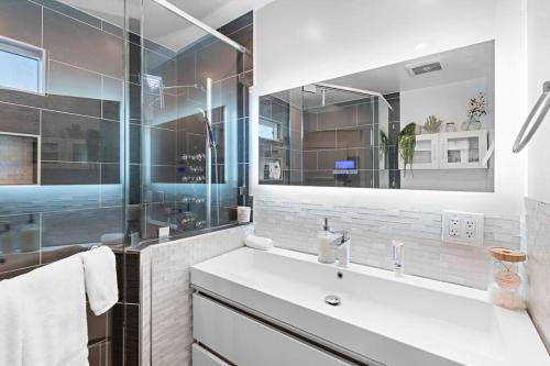 een witte badkamer met een wastafel en een spiegel bij ৎ୭ Luxury Reseda with Pool ৎ୭ in Los Angeles
