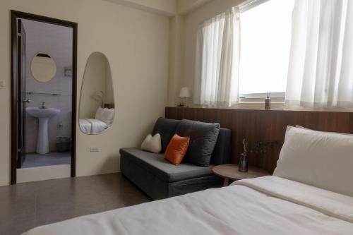a bedroom with a bed and a couch and a mirror at 木子寓所 Moozhouse in Magong