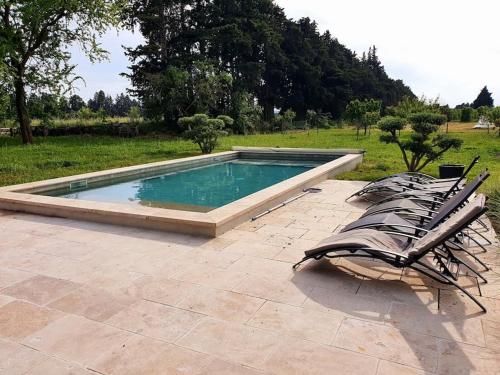 une piscine avec deux chaises longues à côté dans l'établissement Mas du 19eme dans le luberon, à Robion