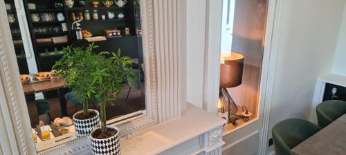 a room with two vases with plants on a window at Hôtel de France in Pléneuf-Val-André