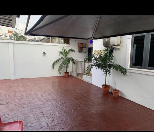a patio with two palm trees and an umbrella at Kings Lux Home in Lagos