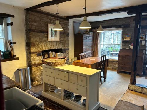 a kitchen with a table and a stone wall at Half Moon House in Hay-on-Wye