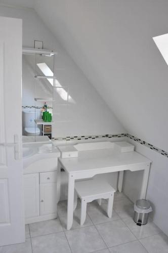 une salle de bain blanche avec un lavabo et un miroir dans l'établissement NormanD Holiday Home - VIRE CALVADOS Relaxing Rural Retreat, à Le Reculey
