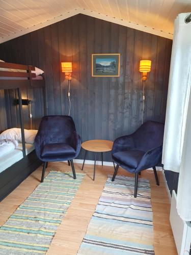 a room with two chairs and a bed and a table at Bjørgebu campung as in Mysusæter
