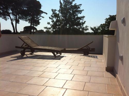 a bench sitting on a patio next to a fence at Il Casolare Degli Ulivi in Oria