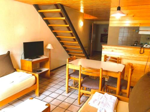 uma sala de estar com uma mesa e uma escada em Apartur Las Leñas em Las Leñas