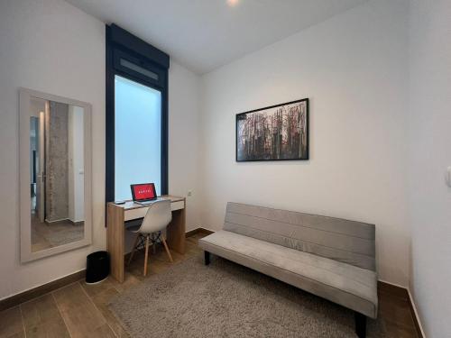 a room with a bench and a desk with a laptop at Precioso estudio en les Corts Valencianes in Valencia