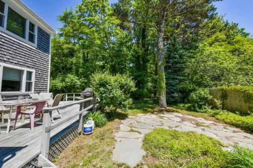a backyard with a wooden deck and a table at Beach Getaway with Private Backyard in Orleans