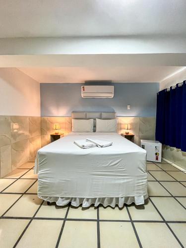 a bedroom with a large white bed with two lamps at Sonho de Iracema Hostel Boutique in Fortaleza