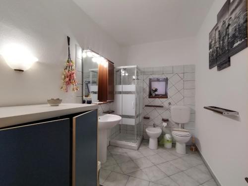 uma casa de banho com um WC, um lavatório e um WC. em Vicky's B&B by V em Papasidero