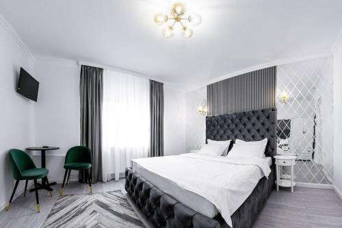 a bedroom with a large bed and a green chair at VALEA MAGURII in Novaci-Străini