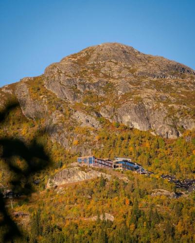 a train on a hill with a mountain at Skarsnuten Mountain Resort & SPA in Hemsedal
