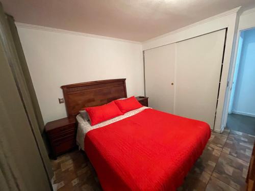 a red bed with red pillows in a bedroom at VISTA LA CIUDAD Y MAR PISO ALTO 1D in Antofagasta