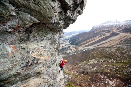 a person is climbing up a rocky mountain at Skarsnuten Mountain Resort & SPA in Hemsedal
