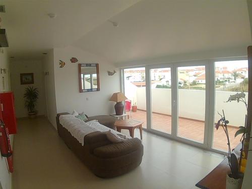 a living room with a couch and a table at Hotel Baleal Spot in Baleal
