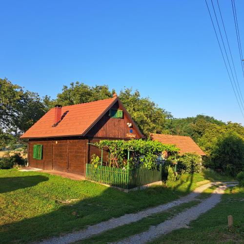 a house with a red roof and a fence at Kokotova hiža in Gornja Konjšćina