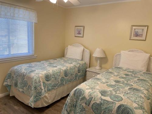 - une chambre avec 2 lits et une fenêtre dans l'établissement Lighthouse Point Rental 2C, à Tybee Island