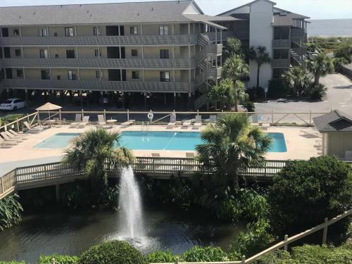 a pool with a fountain in front of a building at Lighthouse Point Rental 2C in Tybee Island
