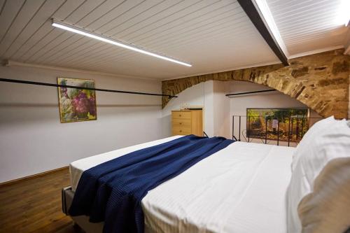 a bedroom with a large bed with a stone wall at The Wine House in Chios