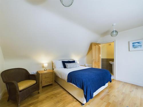 a bedroom with a bed and a chair at Mourne Mountain Bliss, Rostrevor 4BR Cottage with Patio & BBQ ideal for a relaxing getaway in Rostrevor