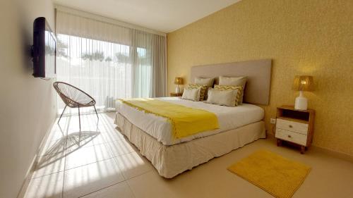 a bedroom with a large bed with a yellow blanket at Herdade dos Salgados - 5b2a in Galé