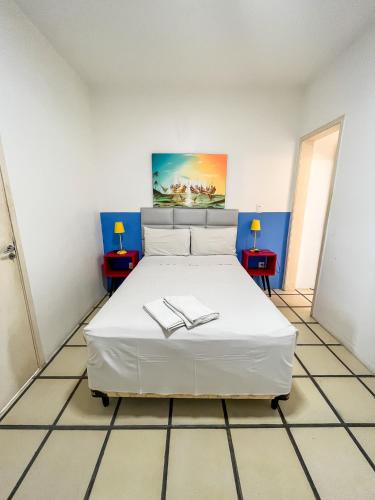a bedroom with a white bed with two tables at Sonho de Iracema Hostel Boutique in Fortaleza