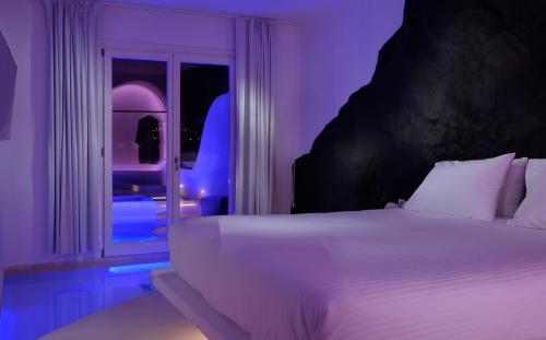 a bedroom with a white bed and a window at Million Stars Mykonos in Mýkonos City