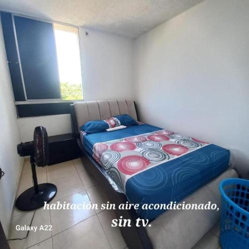 een kleine slaapkamer met een bed in een kamer bij APARTAMENTO AMOBLADO - SIN AIRE ACONDICIONADO in Valledupar