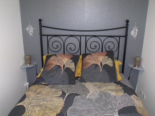 - un lit avec une tête de lit noire et 2 oreillers dans l'établissement Allées d'Etigny T1Bis 41 m2 1 chambre 4 couchages 200 m de la Crémaillère Express 400 m des Thermes, à Luchon