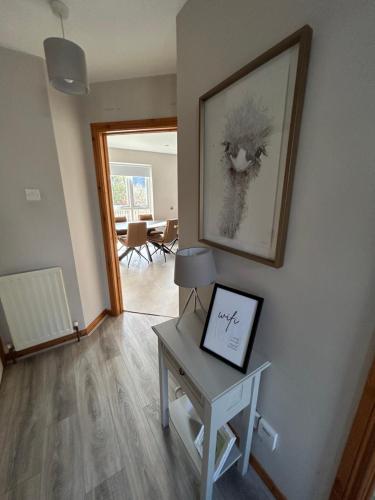 a living room with a table and a picture on the wall at Hopefield House, Portrush in Portrush