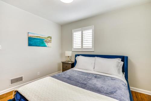um quarto com uma cama azul e uma janela em Family-Friendly SLC Home Near Skiing and Hiking! em Holladay