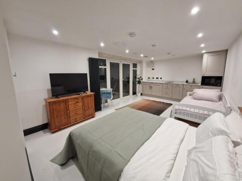 1 dormitorio con 1 cama y TV de pantalla plana en Garden Apartment, sleeps 4, en Leighton Buzzard