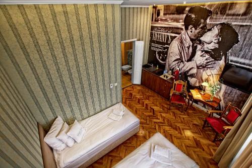 um pequeno quarto com uma cama e um cartaz de filmes em Stare Kino Cinema Residence em Lódź