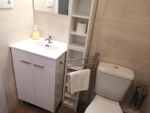 a bathroom with a white toilet and a sink at ApartEasy - Atic Sants in Barcelona