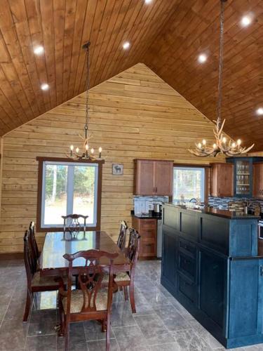 a dining room with a table and a kitchen at Geese Villa Log House in Harrington