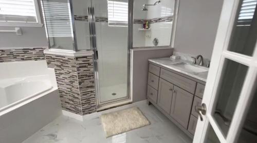 a white bathroom with a shower and a sink at Kildrummy Lux Apartment in Davenport