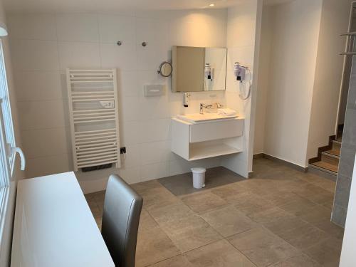 une salle de bain avec un lavabo et un miroir dans l'établissement Logis Hôtel Restaurant Le Moulin de la Coudre, à Venoy