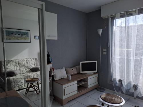 un salon avec un lit et une télévision dans l'établissement Studio COSY Front de Mer, à Royan