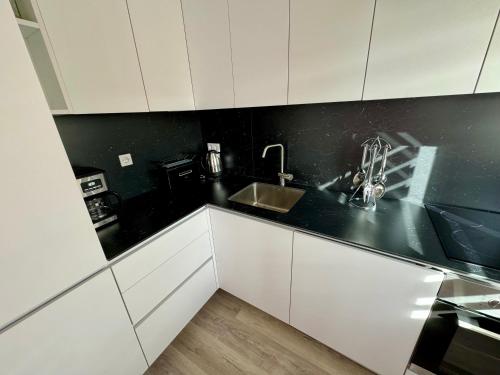 a kitchen with white cabinets and a sink at Haus der Sonne in Soltau